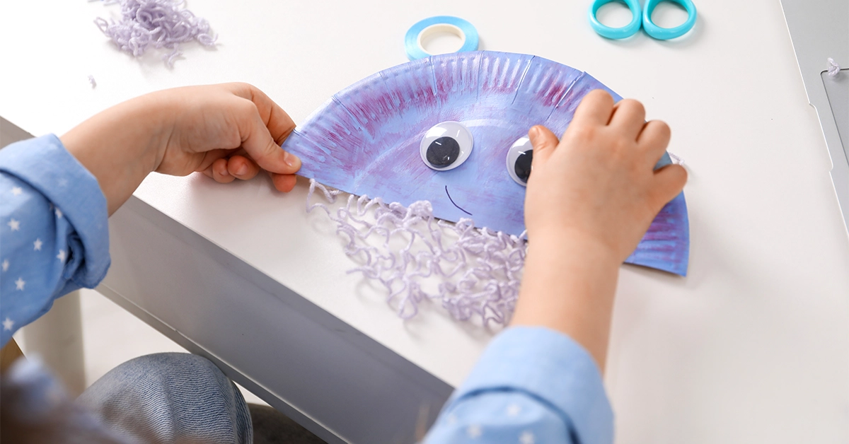 Kid making creative items in the arts and crafts section of Orange Wheels