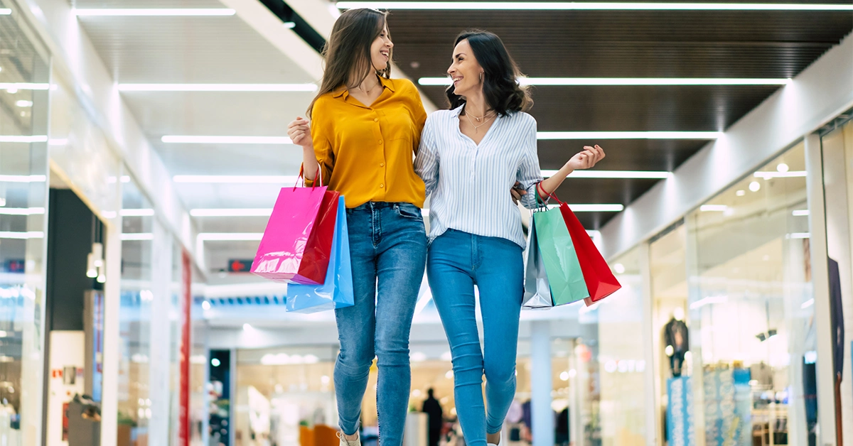 Two young girls exploring different stores in a mall