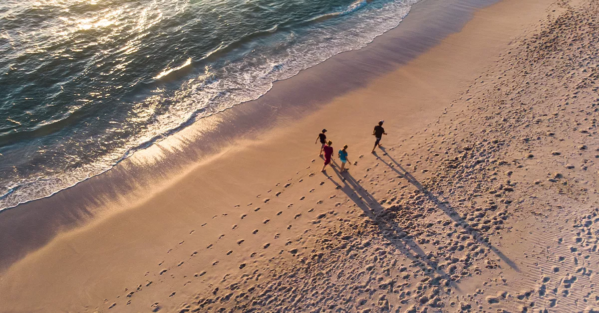 People enjoying a stroll on soft sands at Halat Al Bahrani