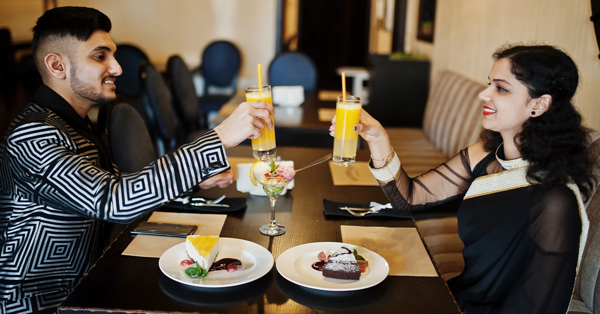 A couple enjoying juice and cake at an Al Noaf restaurant