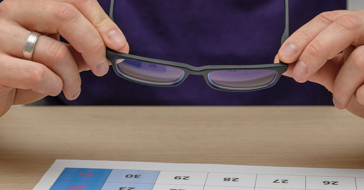 Man holding blue light glasses