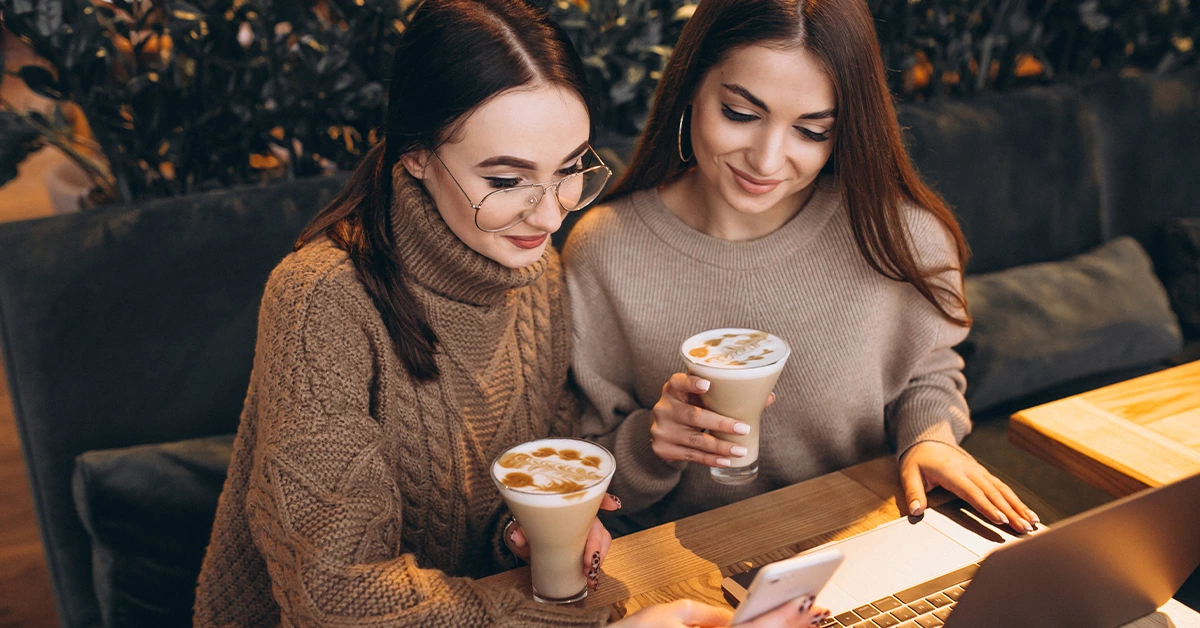 Two girls working while sipping coffee