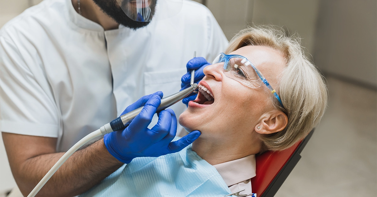 A dentist performing a dental procedure on a female patient in Easy Care Medical Centre