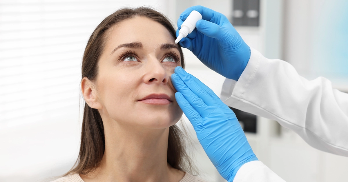 octor applying drops into a patient’s eyes
