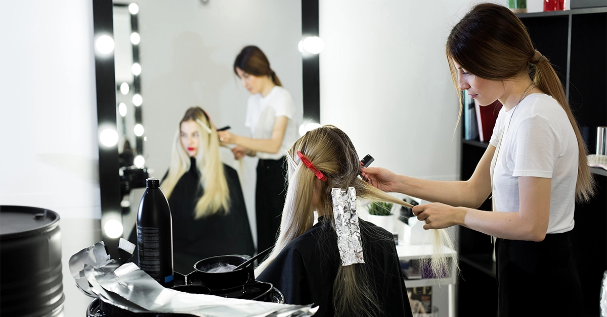 A stylist providing hair colour services at Elata Beauty Salon