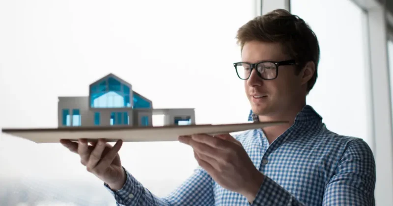 man holding cardboard house