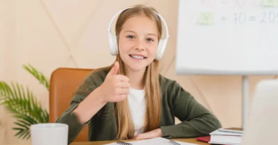 A kid pointing with thumbs up as she joins an online school group