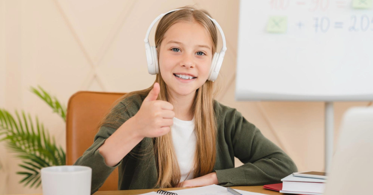 A kid pointing with thumbs up as she joins an online school group