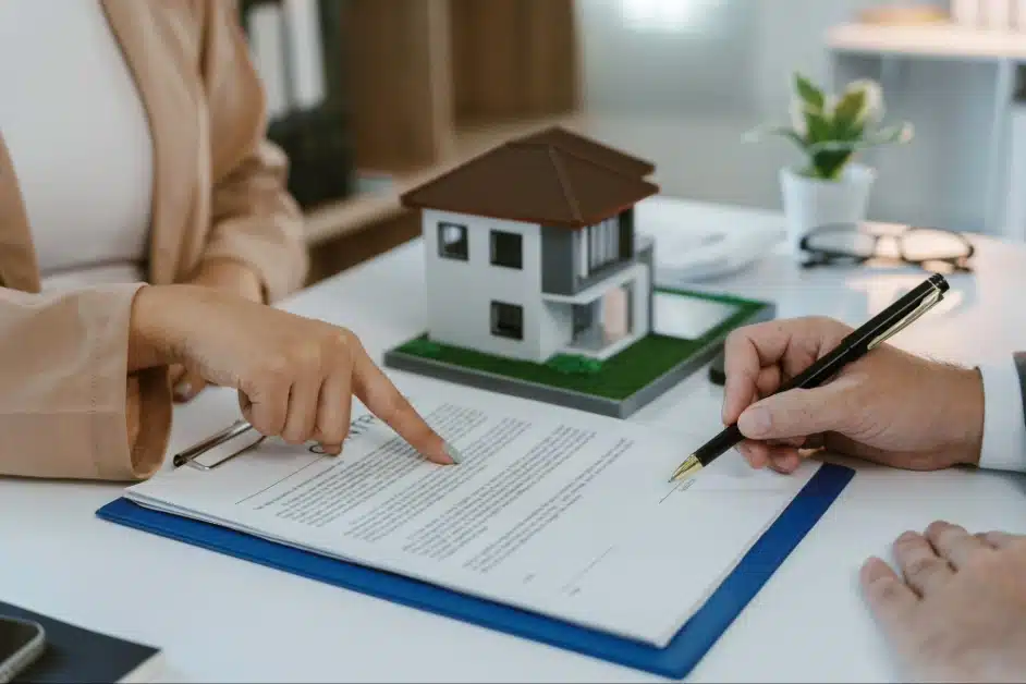 Real estate agent guiding client to sign property purchase contract