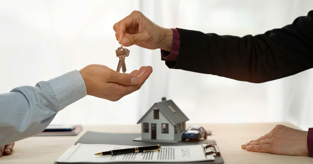 Man handing over keys over contract to show Abu Dhabi property taxes
