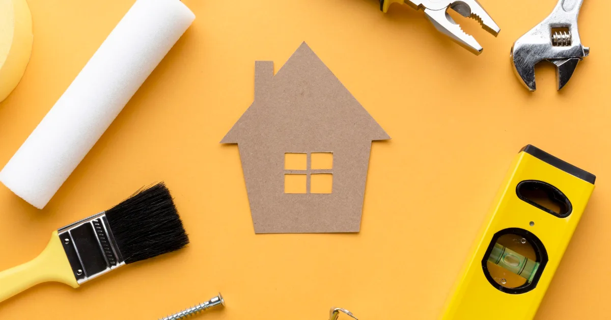 Cardboard house with tools flat lay