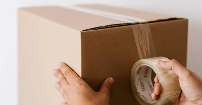 Alt text: Packing a box to move from India to Dubai to show the cost of living in Dubai vs India