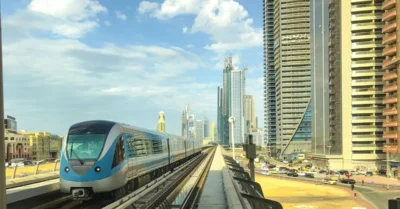 Modern Dubai Metro train passing through urban cityscape