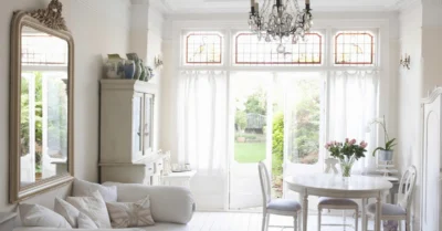 Modern living room with open balcony door to garden, bright morning light