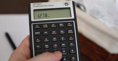 A person using a calculator, possibly to assess utility bills for electricity and water in the UAE