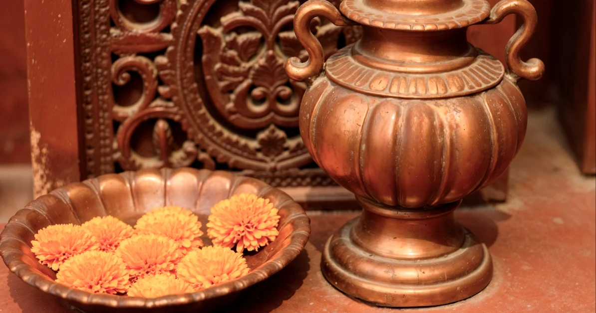 copper vessel with flowers and carved wood