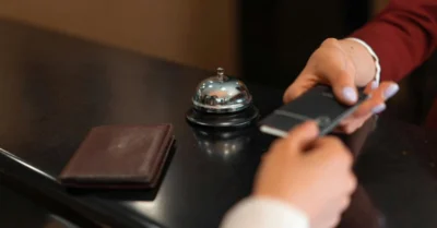 A visitor receiving his hotel room card from the reception