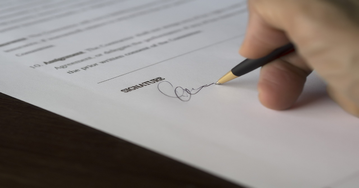 A person signing his home purchase contract.