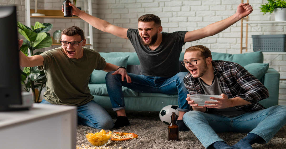 cheerful male friends watching sports on tv together