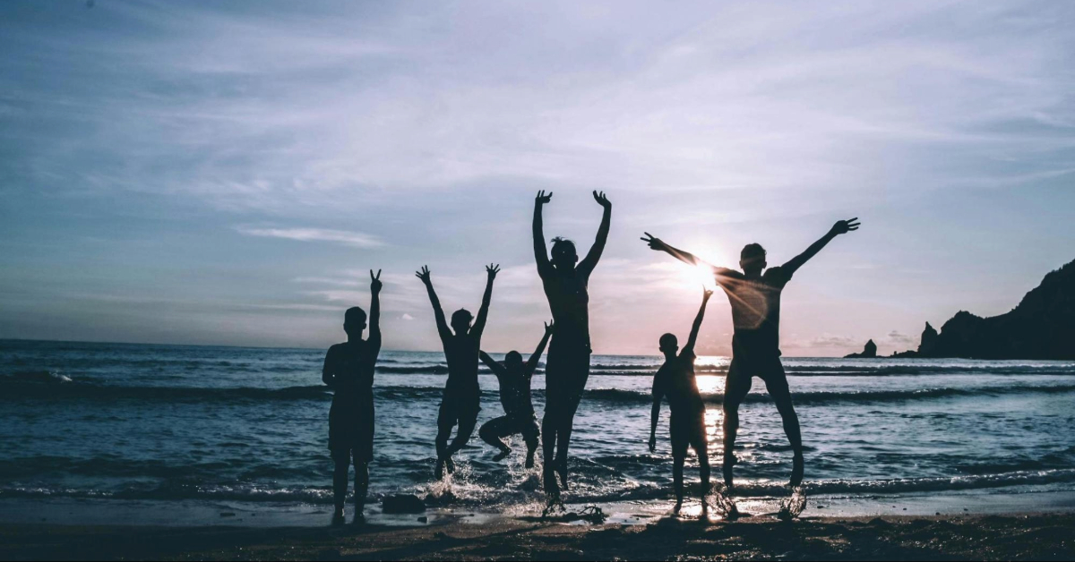 A group of people jumping by the beach