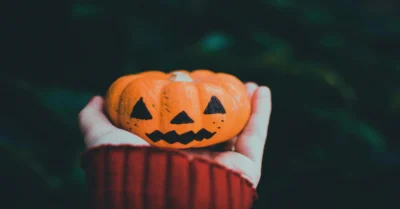 Someone holding Halloween orange pumpkin
