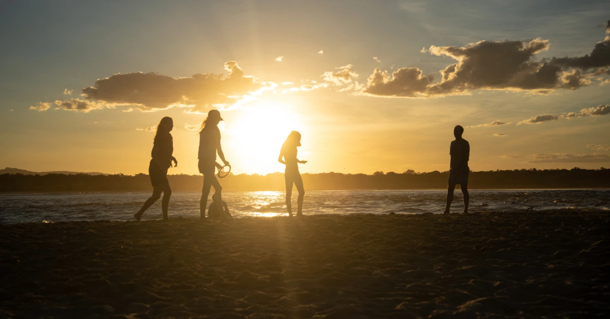 silhouette of family playing on the beach at sunset