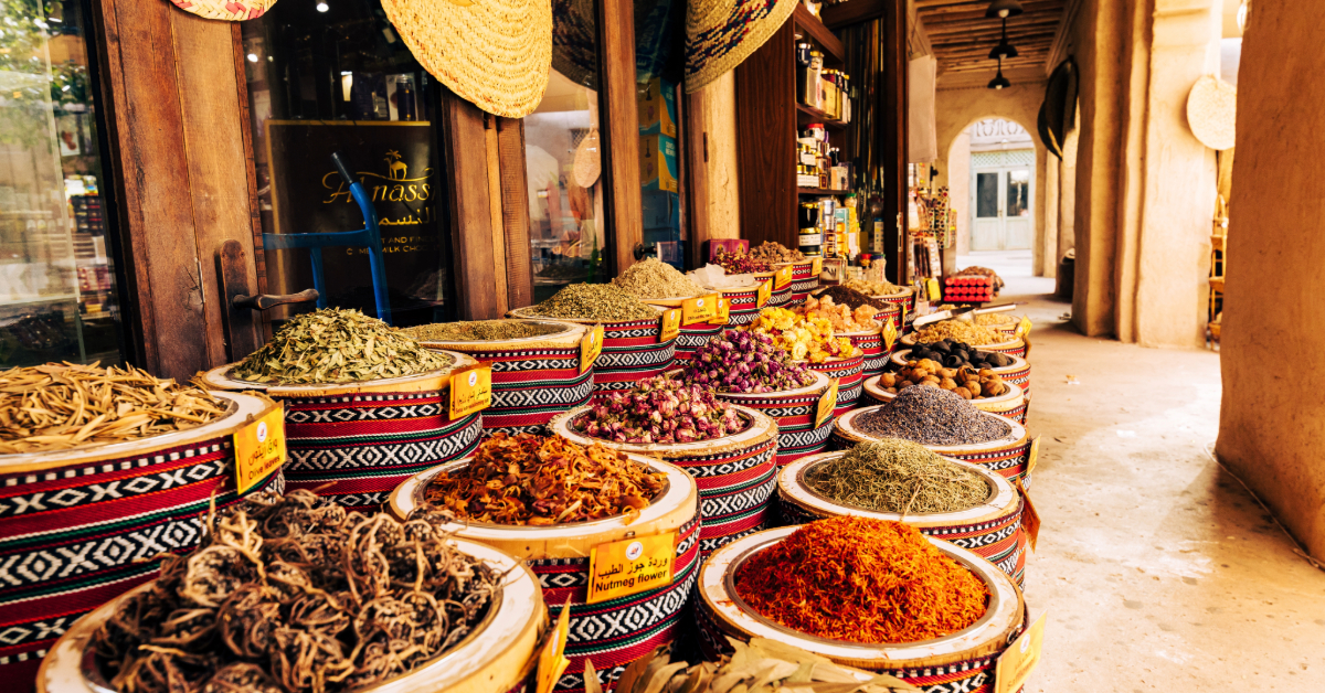 أوعية مليئة بالتوابل والأعشاب الملونة معروضة في محل عطارة بالشارقة