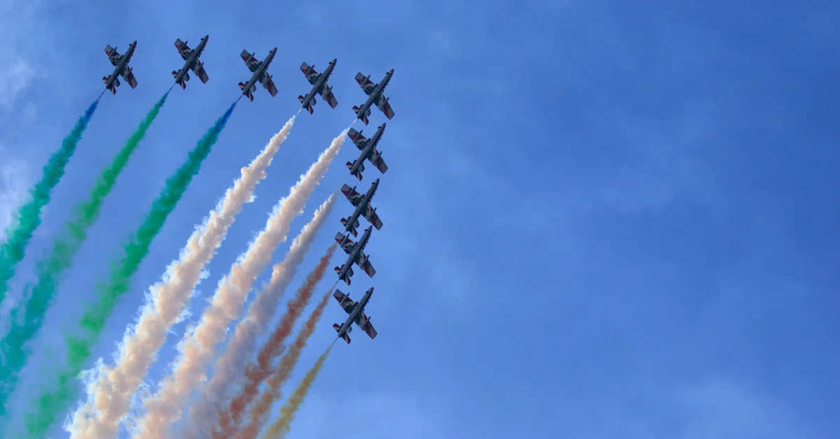 مجموعة طائرات تُطلق دخانًا ملونًا في سماء دبي احتفالًا بمعرض دبي للطيران