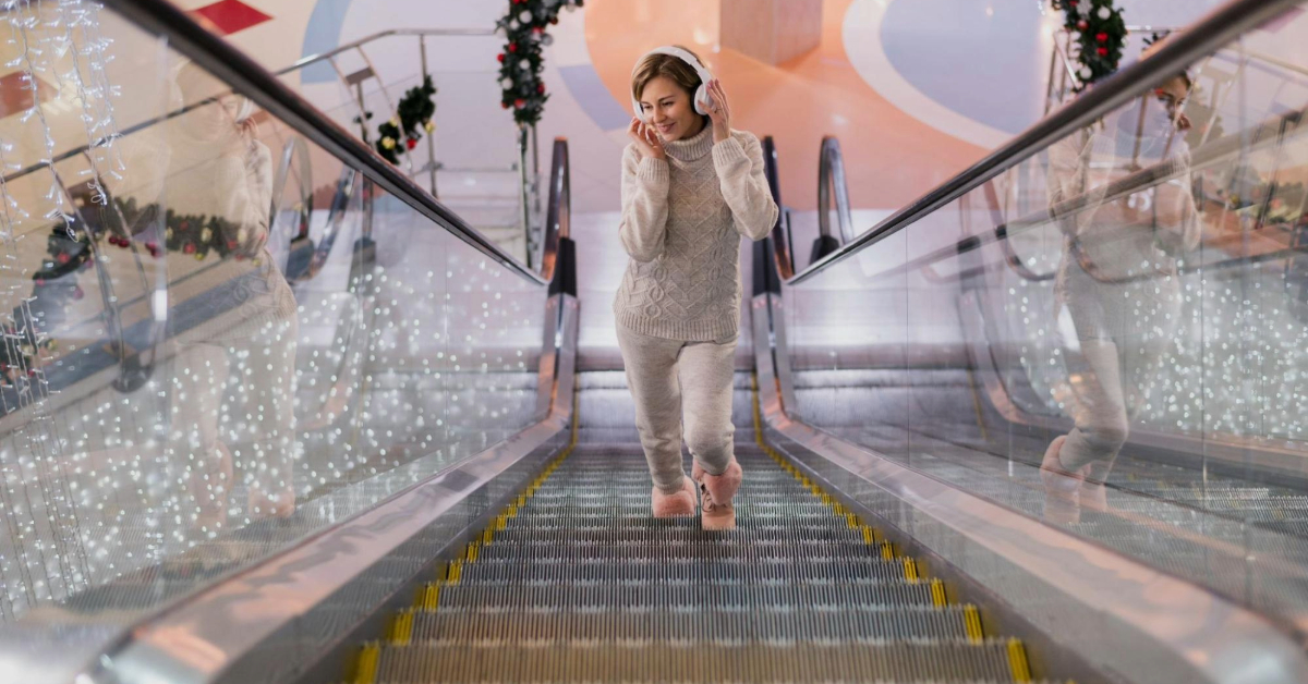 A woman enjoying music in a Christmas-decorated mall