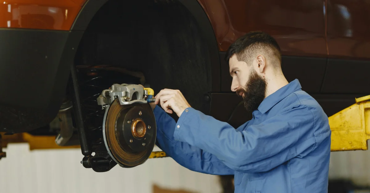 Man checking a car’s brake system in Ajman