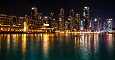 Sparkling dubai skyscrapers reflect in the water at night