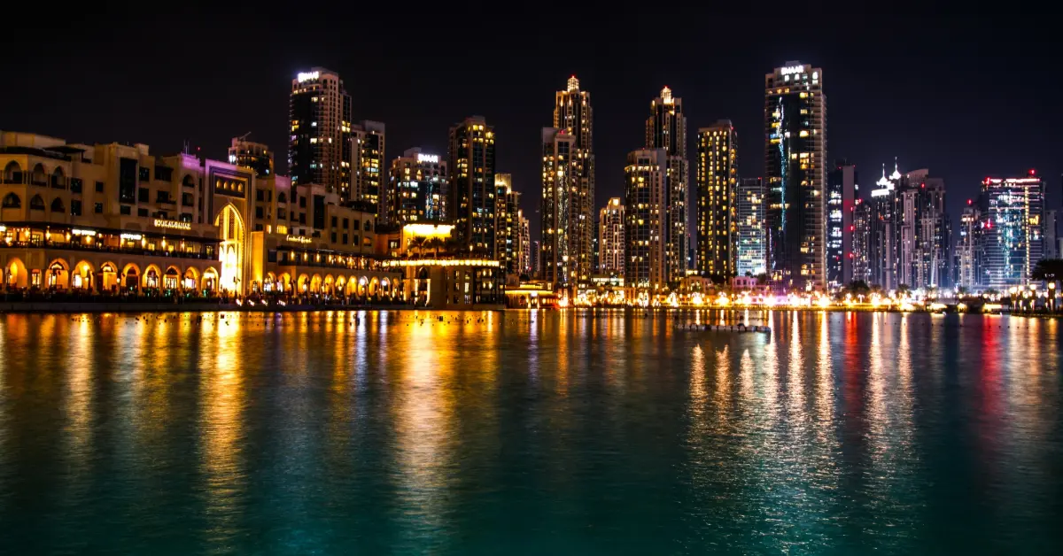 Sparkling dubai skyscrapers reflect in the water at night