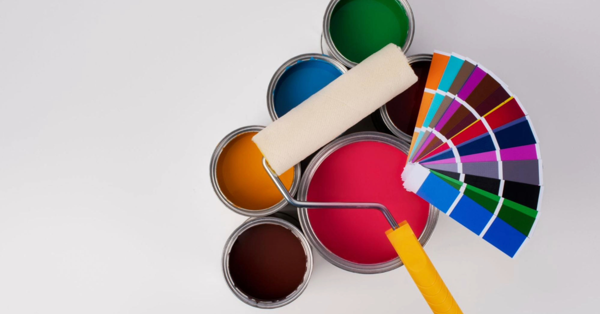 Top view of five paint buckets displayed alongside a shade swatch book.