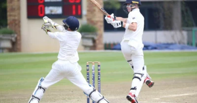 Two boys playing cricket in full gear