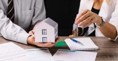 Two real estate agents selling a home to a customer. 