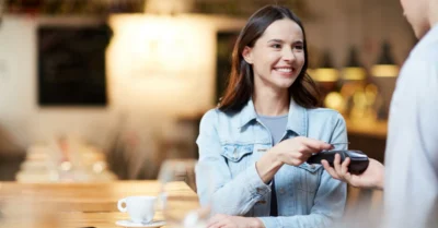 امرأة في مقهى تقوم بدفع الفاتورة