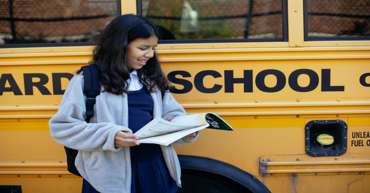 school girl watching exercise book on street