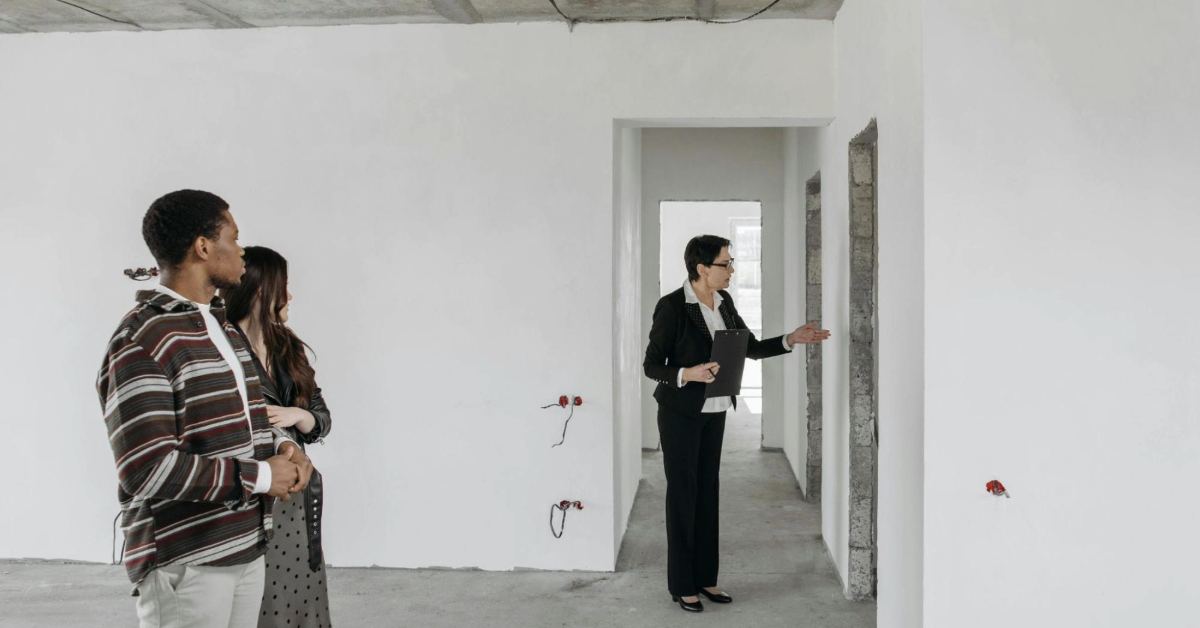 A team of people in an unoccupied room, engaged in a property inspection discussion