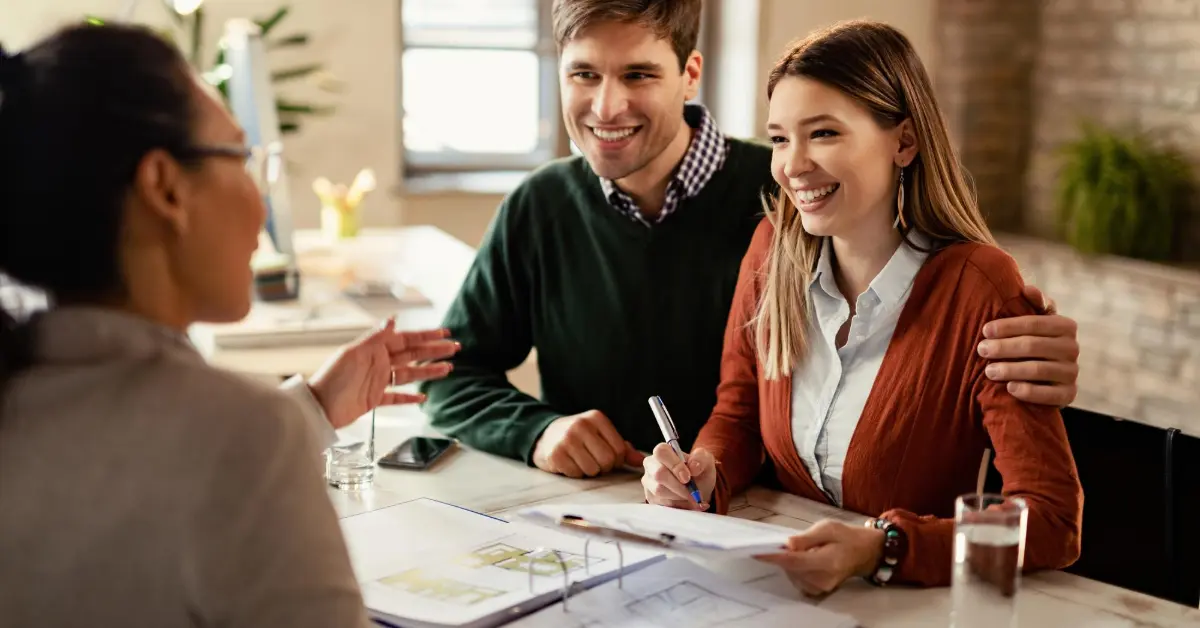 A happy couple signing a house contract with broker