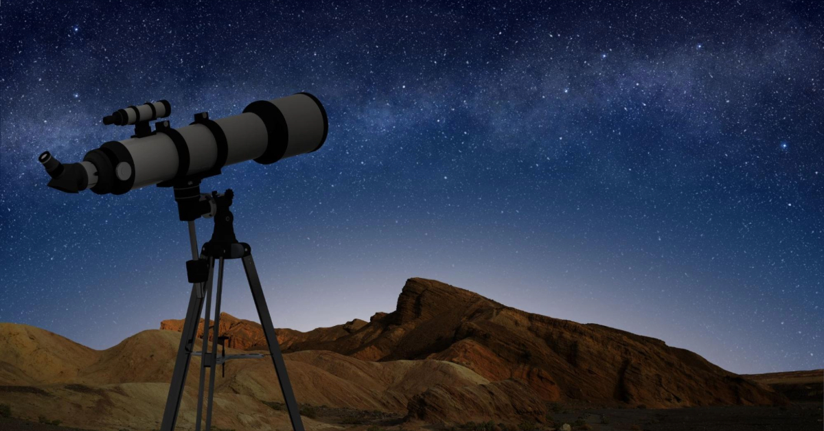 telescope on a tripod pointing at a starry night sky