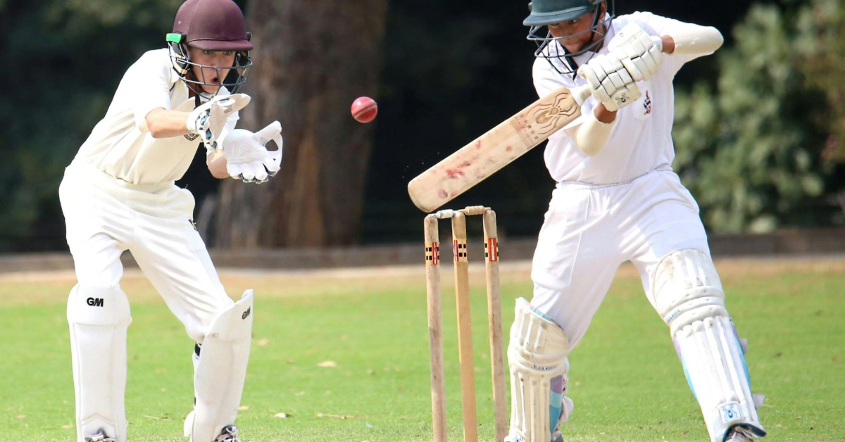 One boy batting and the other wicket-keeping
