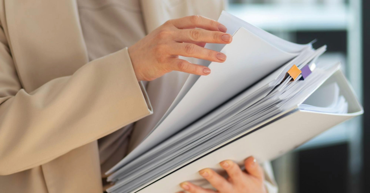 A girl holding a stack of documents