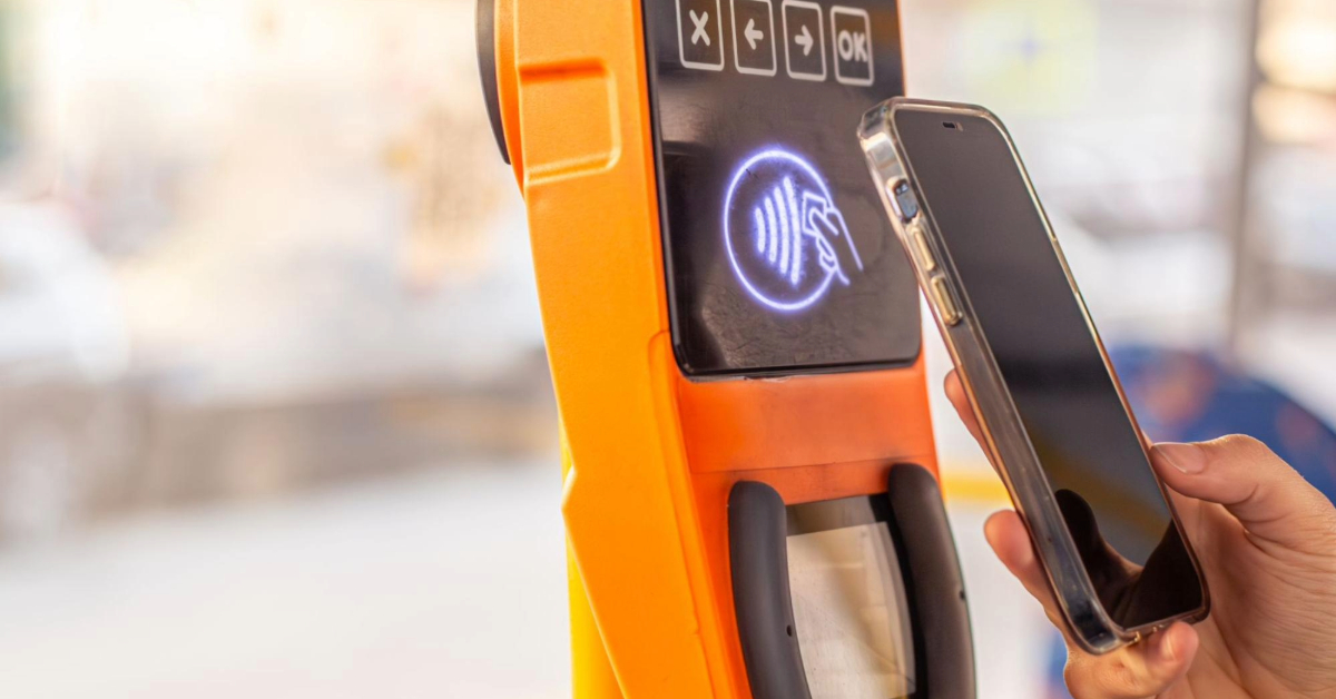 A girl tapping her phone against a cardless public transport reader