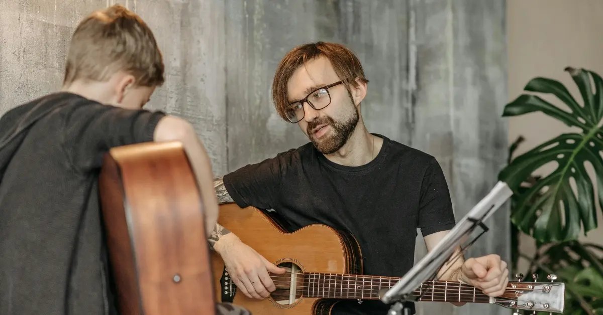A teacher giving guitar lessons