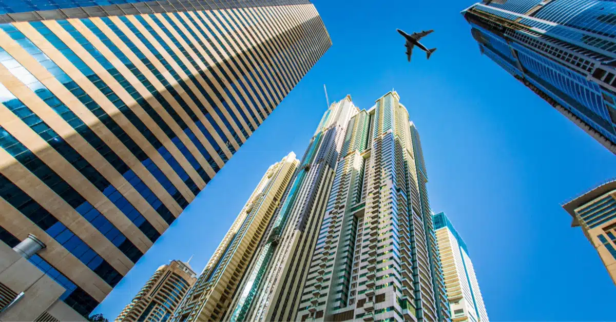 Airplane flying high amidst the towering cityscape of Dubai