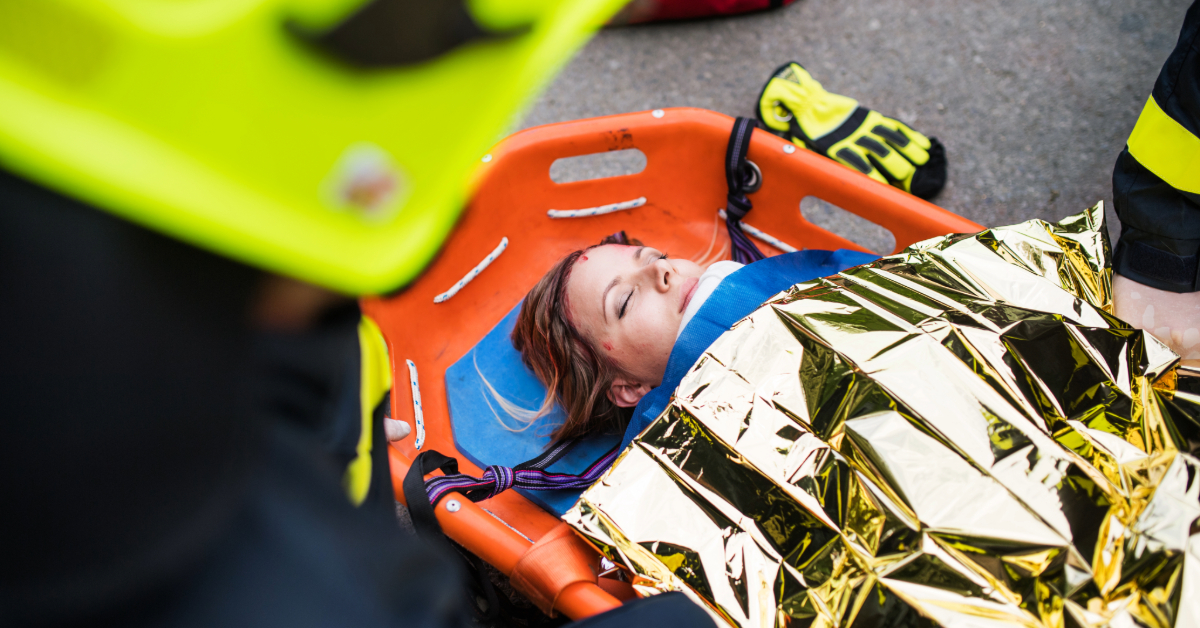 Injured woman on a stretcher being assisted by medical emergency workers