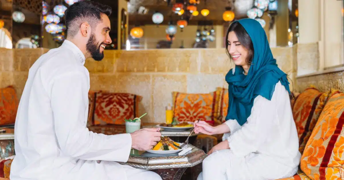 A Muslim couple dining together in a restaurant, enjoying a meal in a relaxed setting