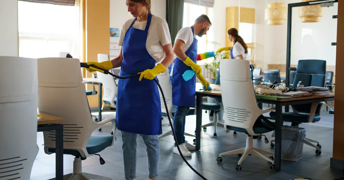 Professional cleaning service person using vacuum cleaner in office