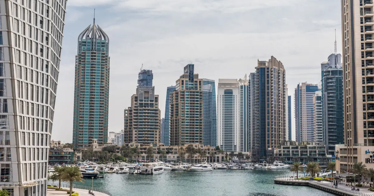 Promenade and canal in dubai marina with luxury skyscrapers around