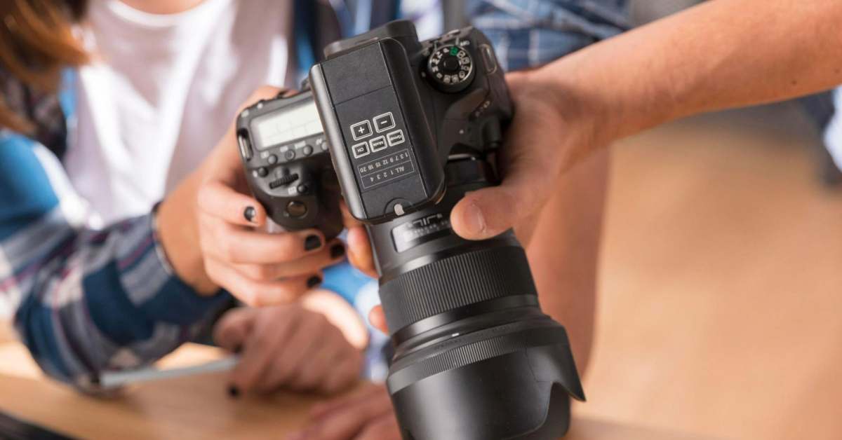 Two people looking through photos on a camera